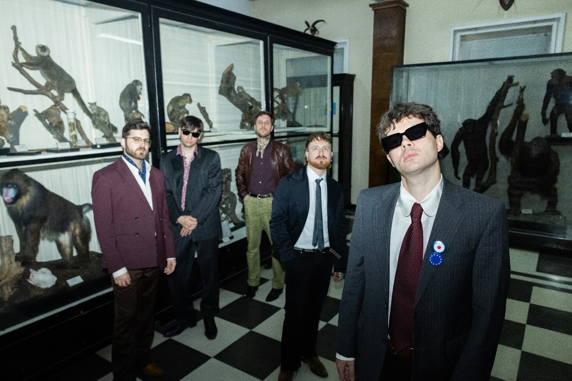 Hayes & Y band photo, five members in suits in front of taxidermy displays